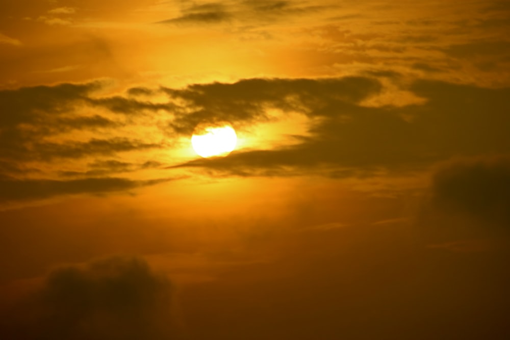 a plane flying in the sky at sunset