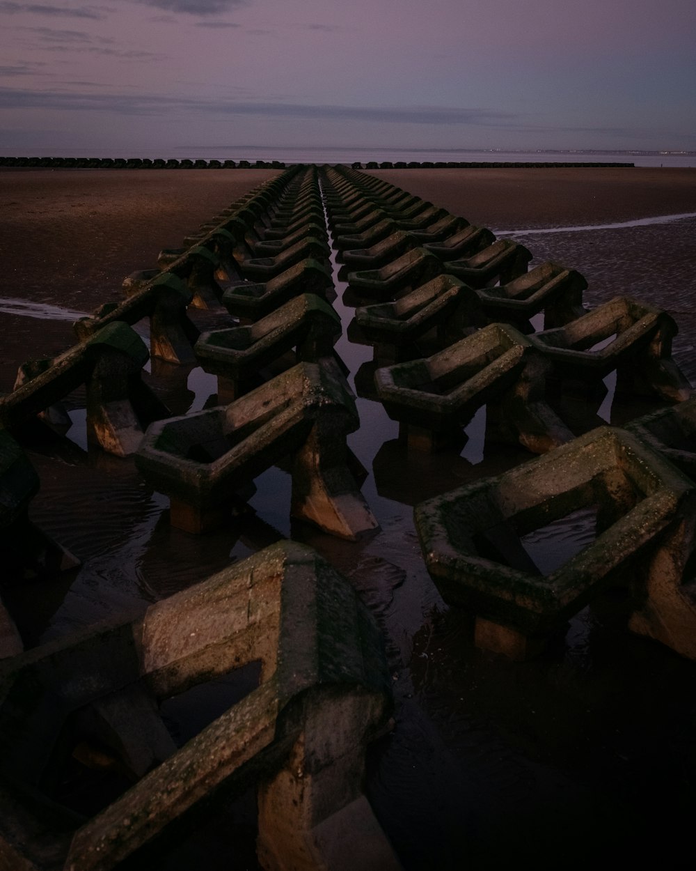 a row of wooden benches sitting on top of a beach