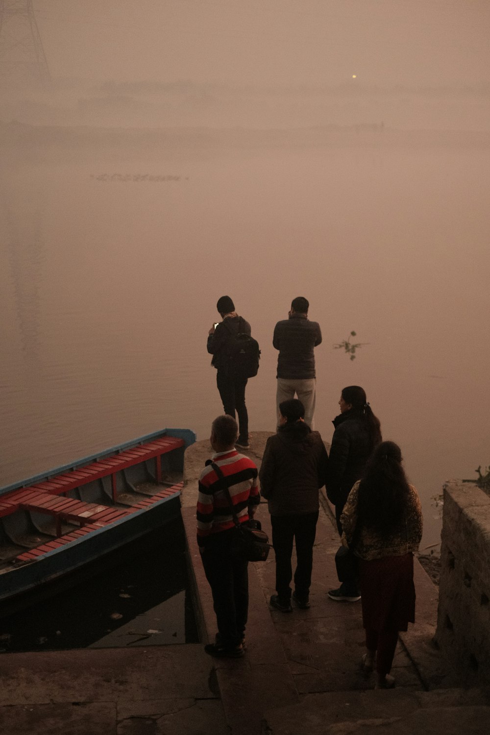 a group of people standing next to a body of water