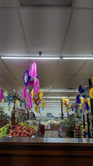 A vibrant supermarket aisle filled with fresh fruits, baked goods, and meat products.