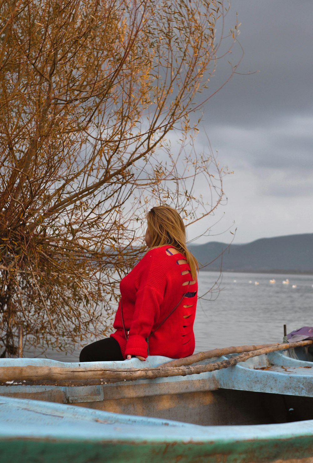 a woman in a red jacket sitting on a boat