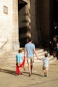 a man and two children are walking down the street