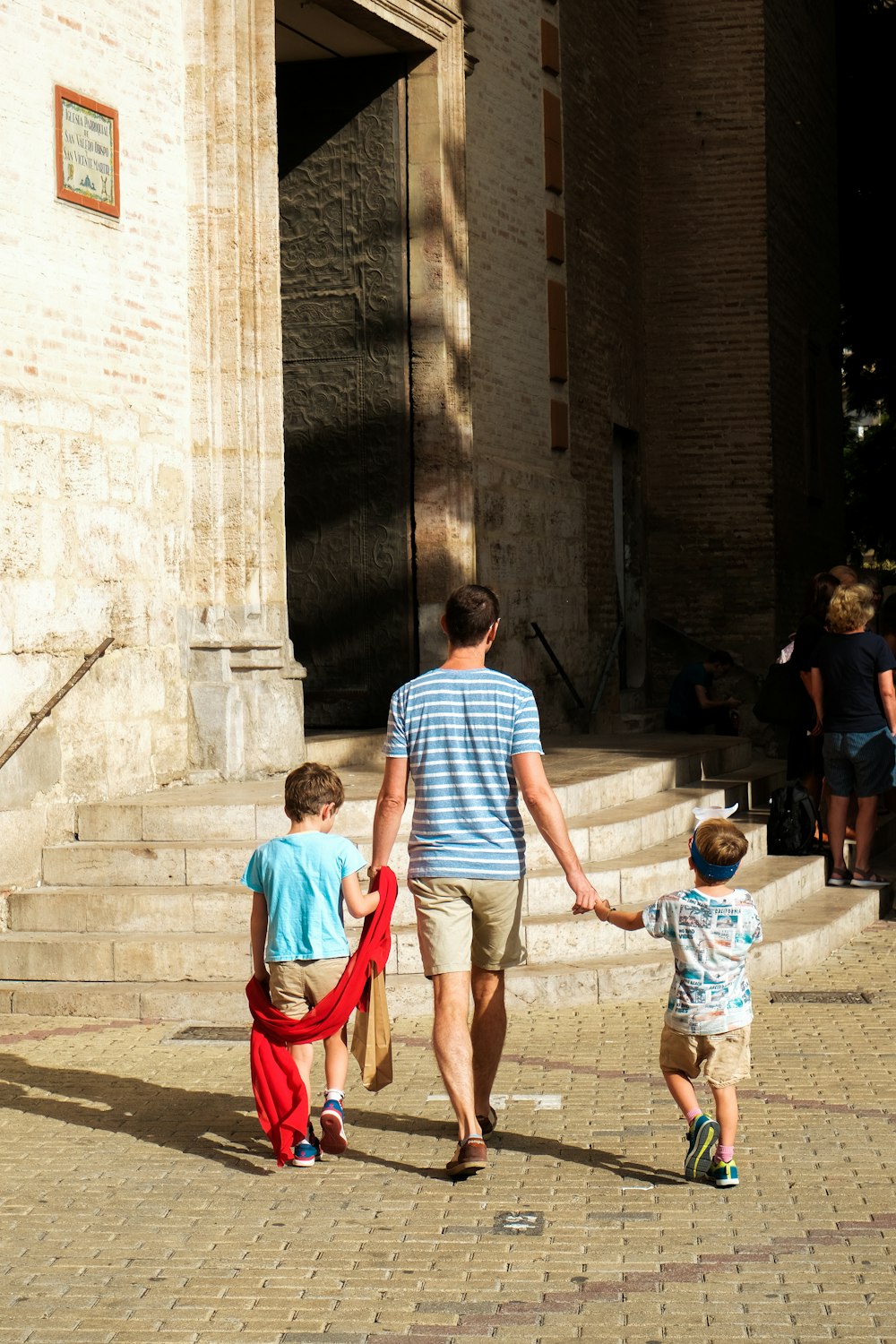 a man and two children are walking down the street