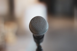 A close-up of a microphone with a blurred urban background.