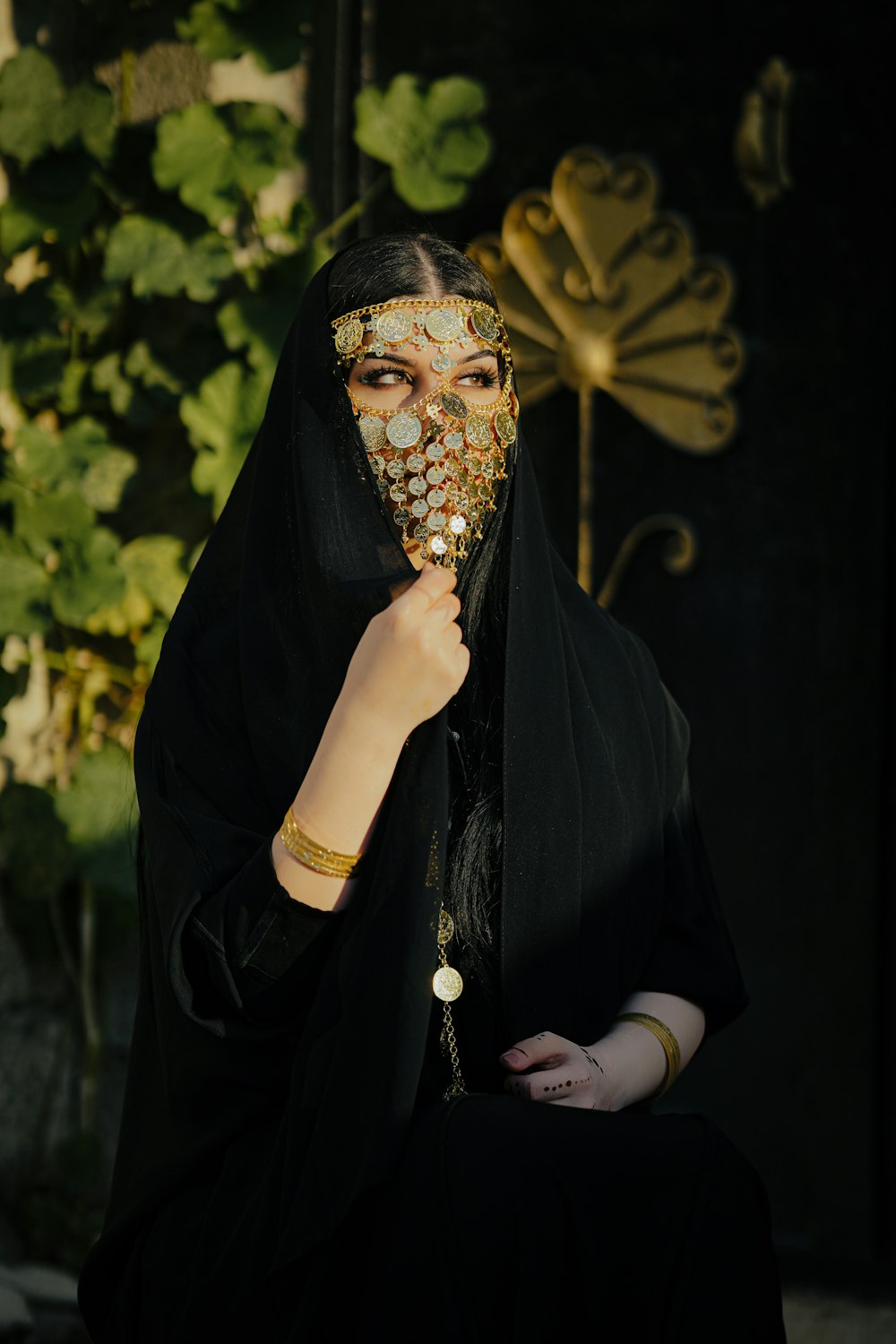 a woman wearing a black veil and gold jewelry
