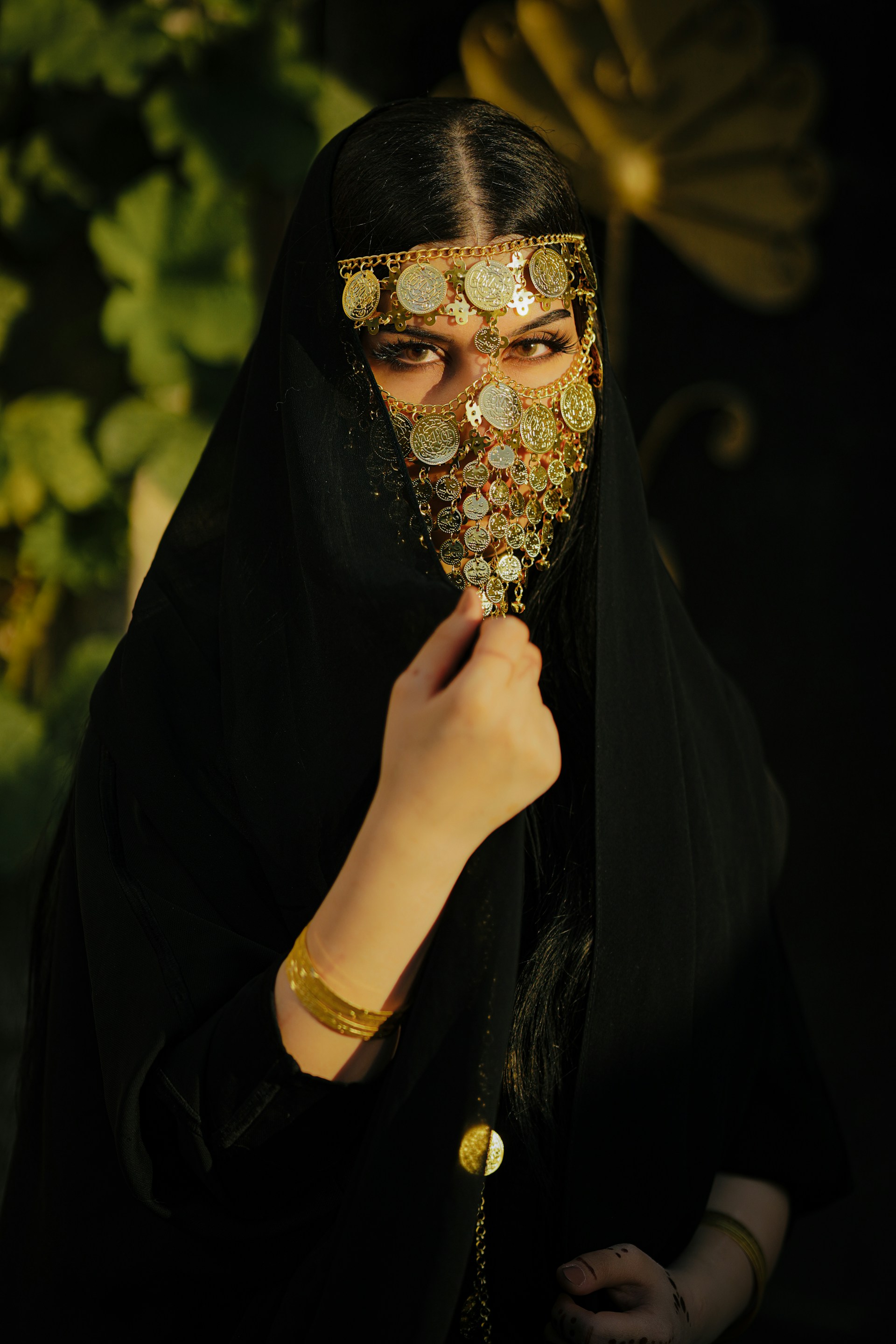 a woman wearing a black veil and gold jewelry