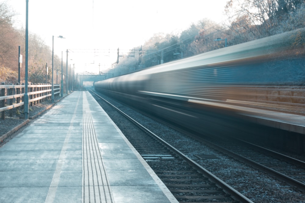 a train traveling down train tracks next to a forest