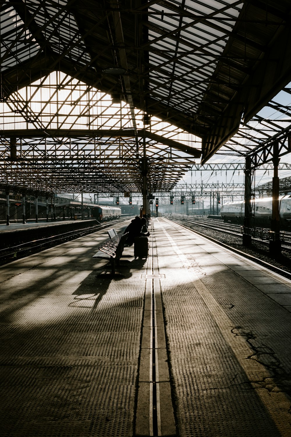 a person sitting on a bench at a train station