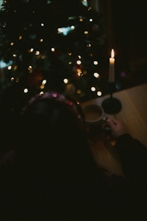 a person sitting at a table in front of a christmas tree