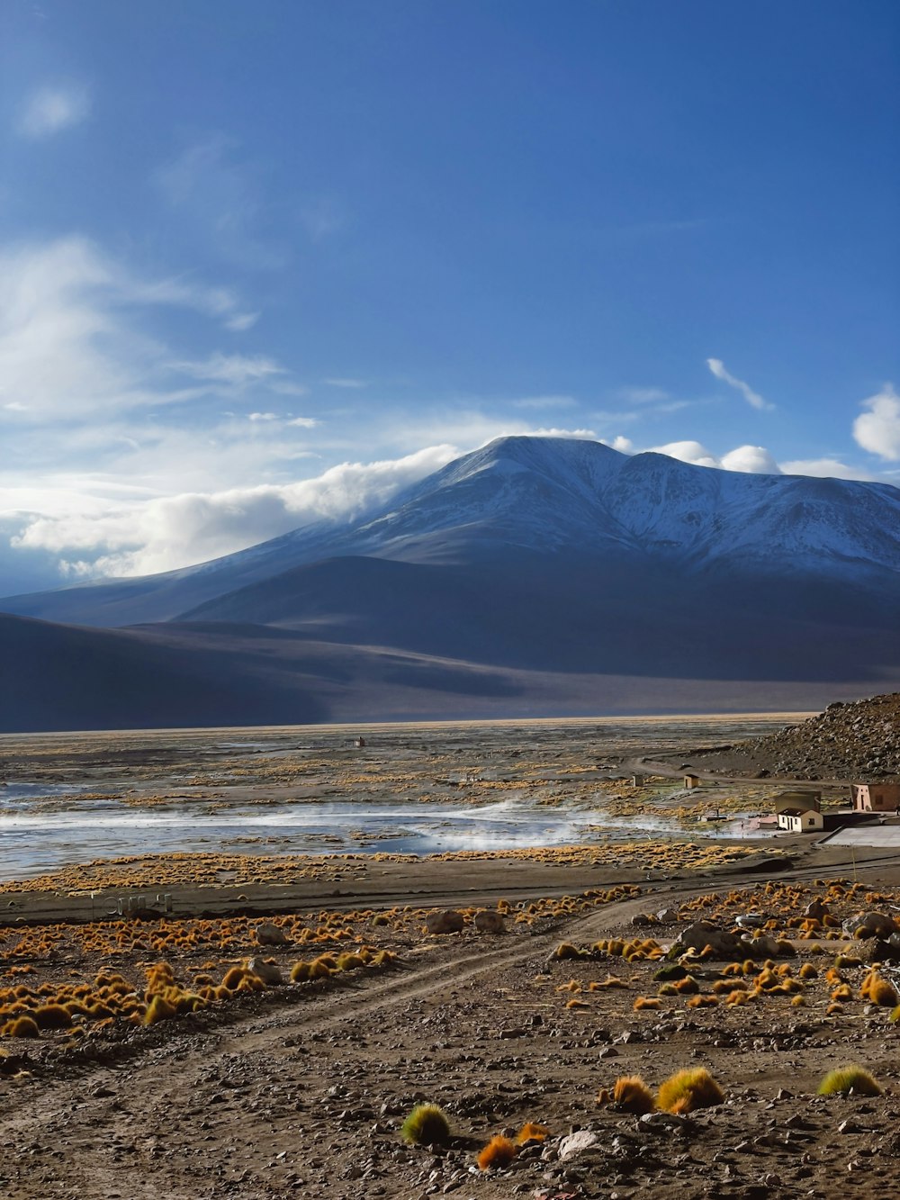 a dirt road with a mountain in the background