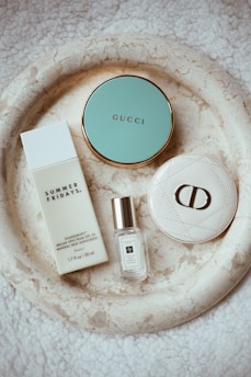 a white plate topped with a bottle of perfume and a bottle of perfume