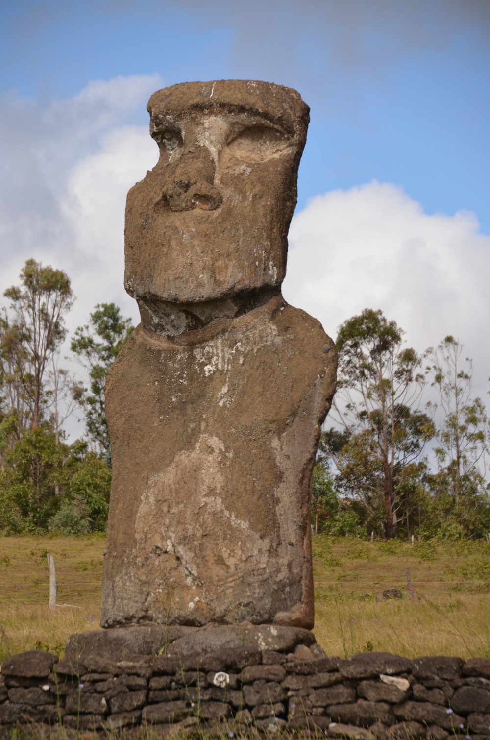a large stone statue in a grassy field