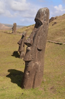 a group of statues sitting on top of a lush green field