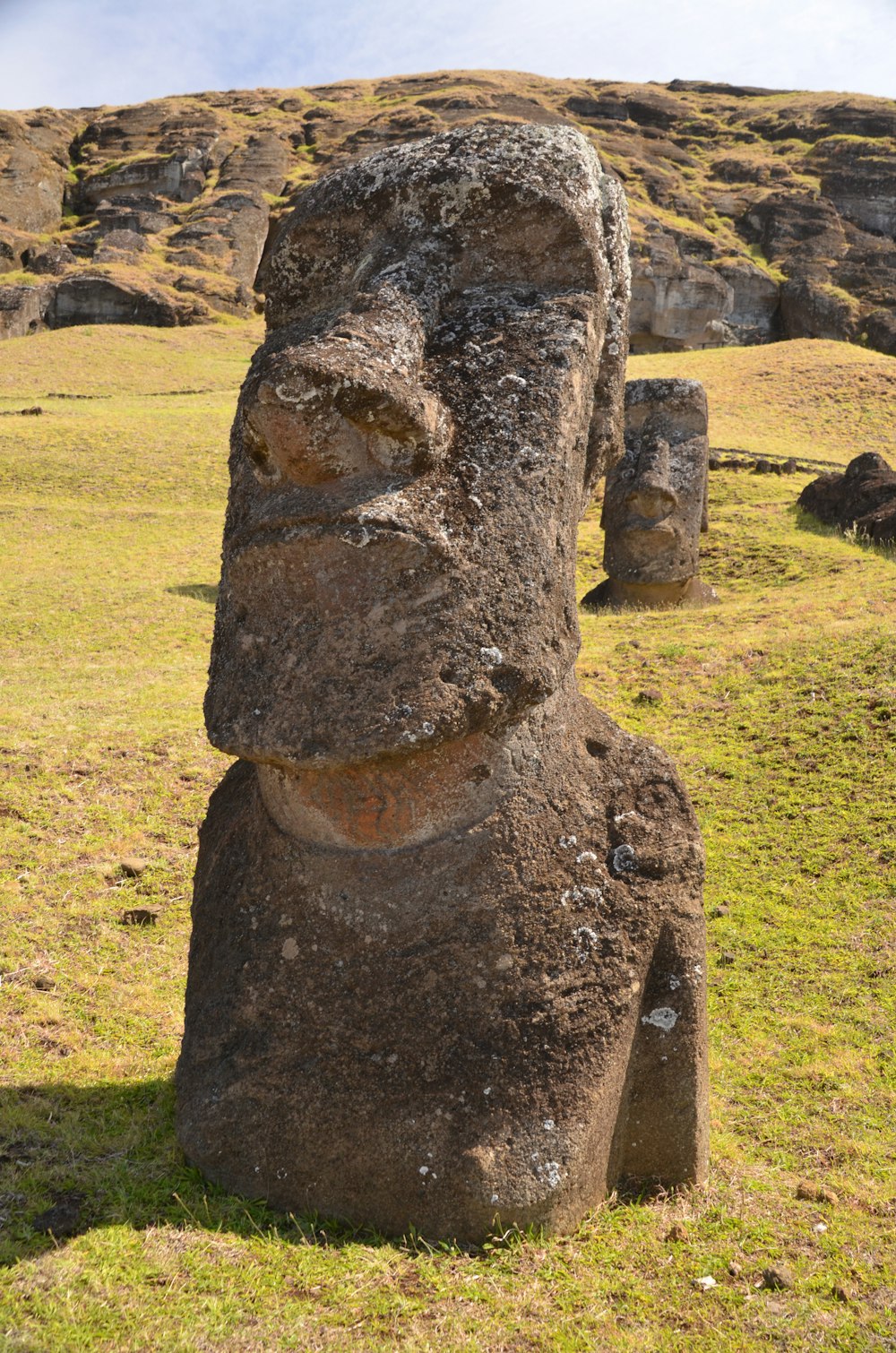 a large stone statue in a grassy field