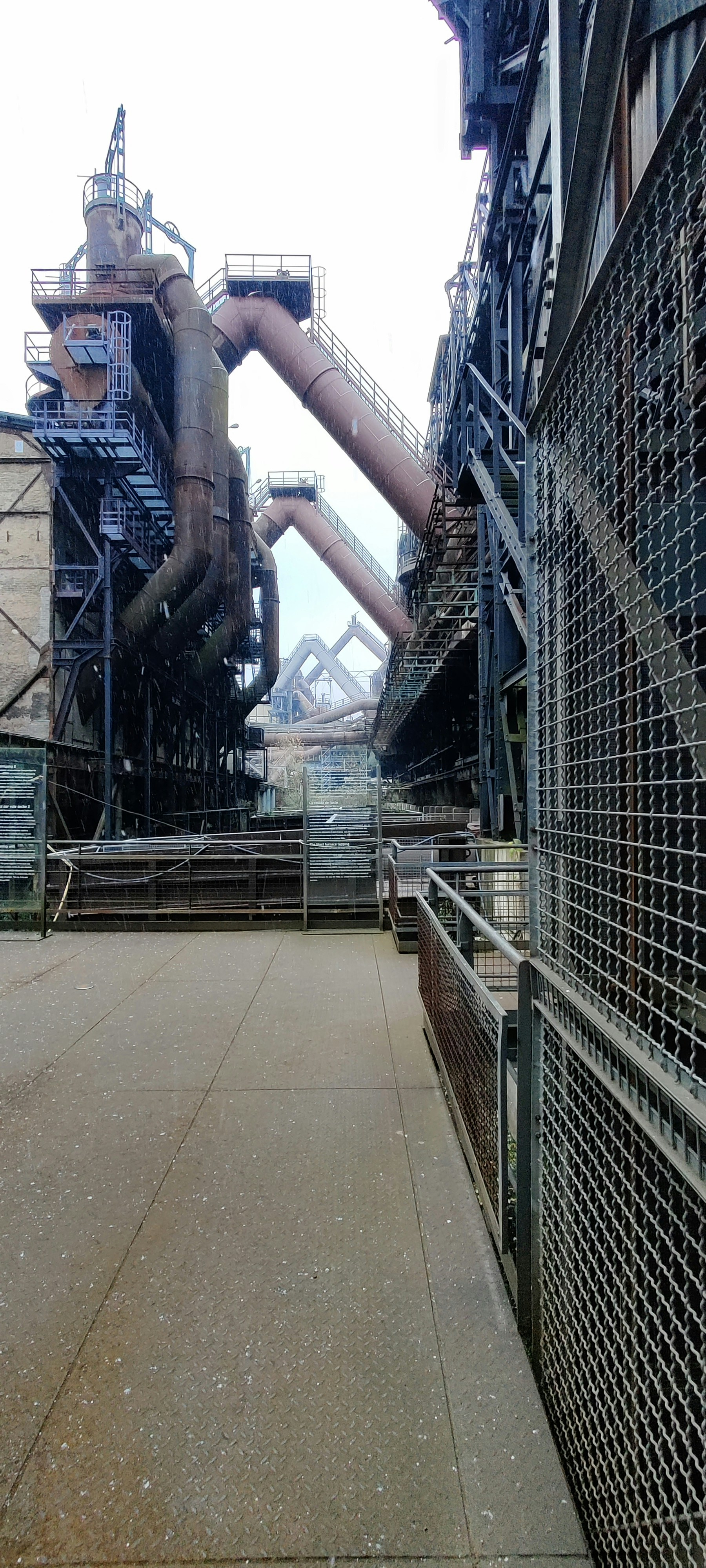 Grey PVC pipe sections in an industrial construction yard, overcast sky, muted tones