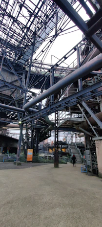 Wide shot of a modern steel fabrication facility with organized workstations and large steel beams.