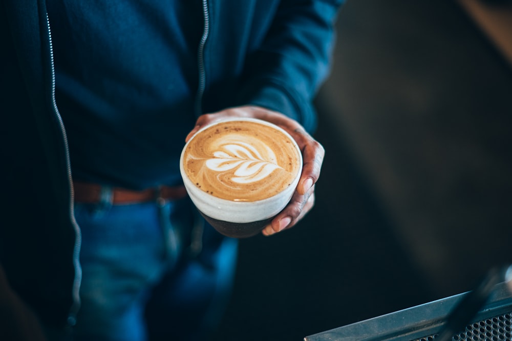 uma pessoa segurando uma xícara de café na mão