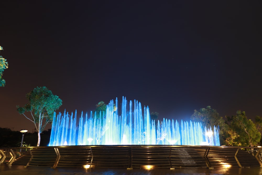 a large fountain of water lit up at night