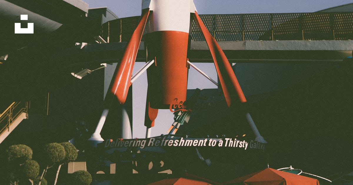 A red and white rocket sitting on top of a building photo – Free ...