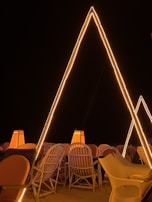 A nighttime scene showcasing Arabic seats illuminated by lanterns, creating a warm and inviting atmosphere.