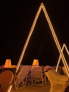 A nighttime scene showcasing Arabic seats illuminated by lanterns, creating a warm and inviting atmosphere.