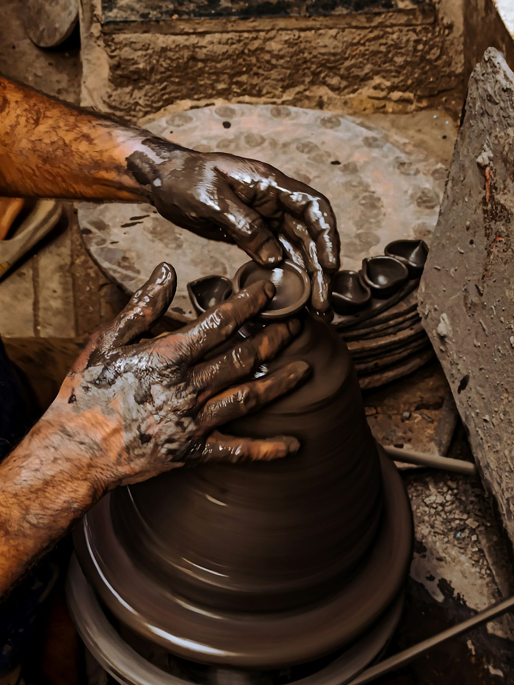 a person making a pot on a potter's wheel