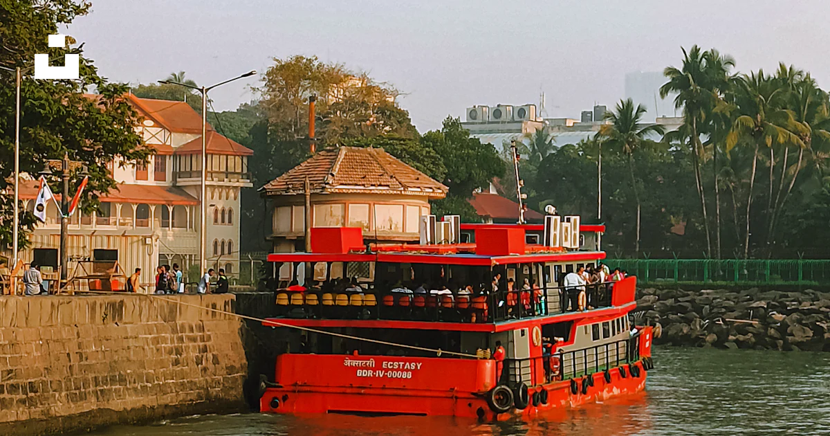 Foto Un bote rojo que viaja río abajo junto a edificios altos – Imagen ...