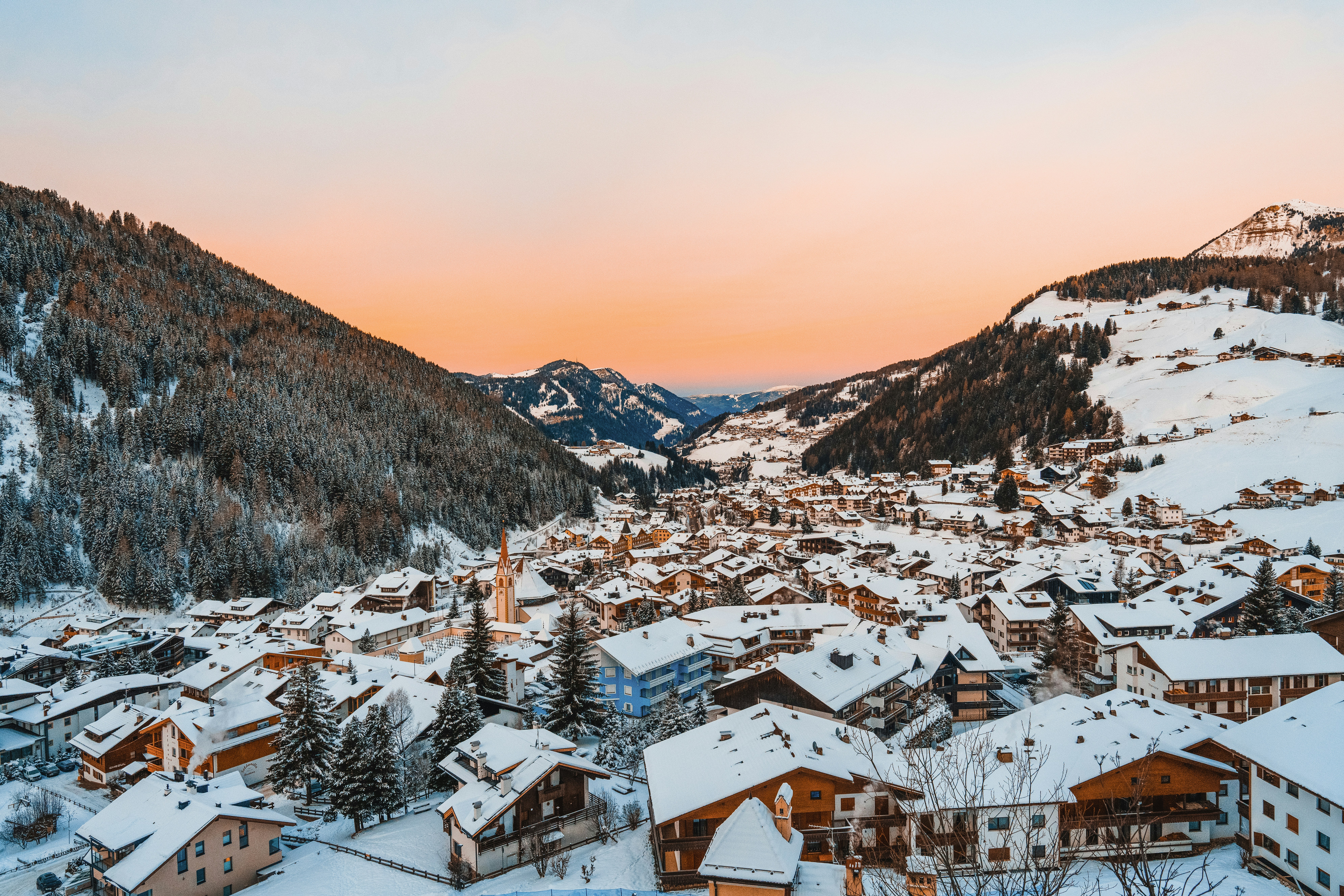 a snowy village with mountains in the background