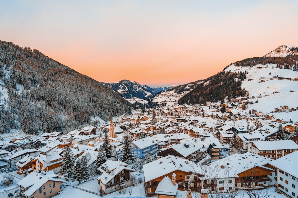 a snowy village with mountains in the background