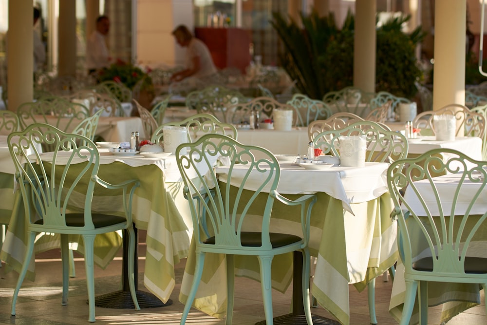 a dining area with tables and chairs and a person in the background