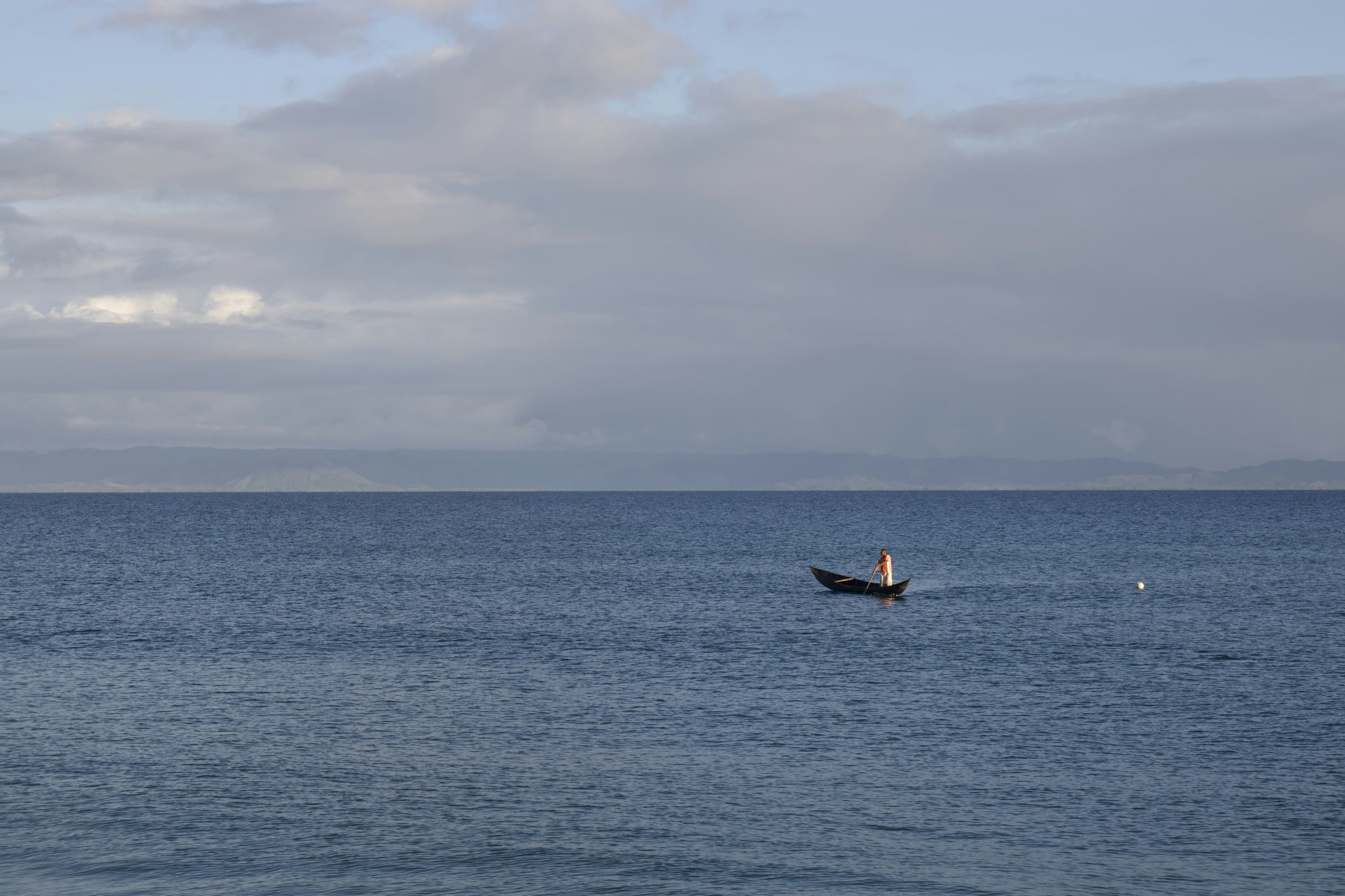 a person in a small boat on a large body of water