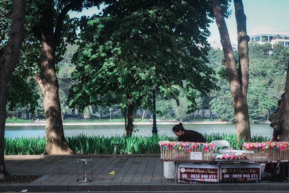 a man sitting on a bench next to a lake