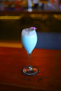 Photo of a stylish blue and gold branded Aloha Drinks cocktail being served at a lively wedding reception in Goiás.