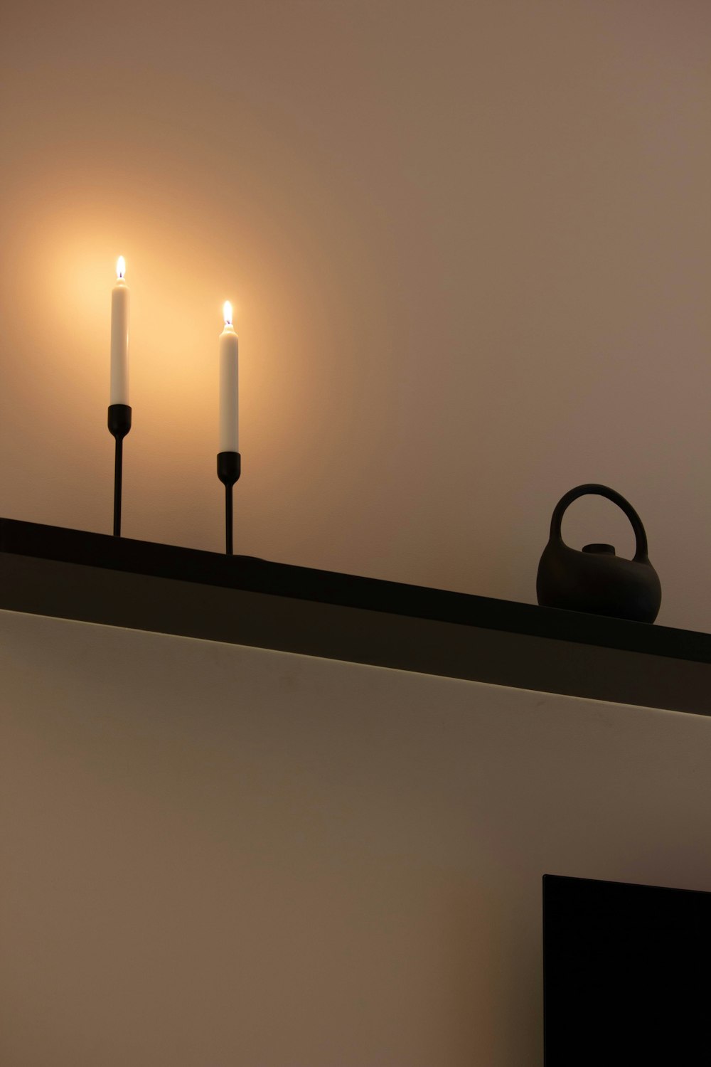 a couple of candles sitting on top of a shelf