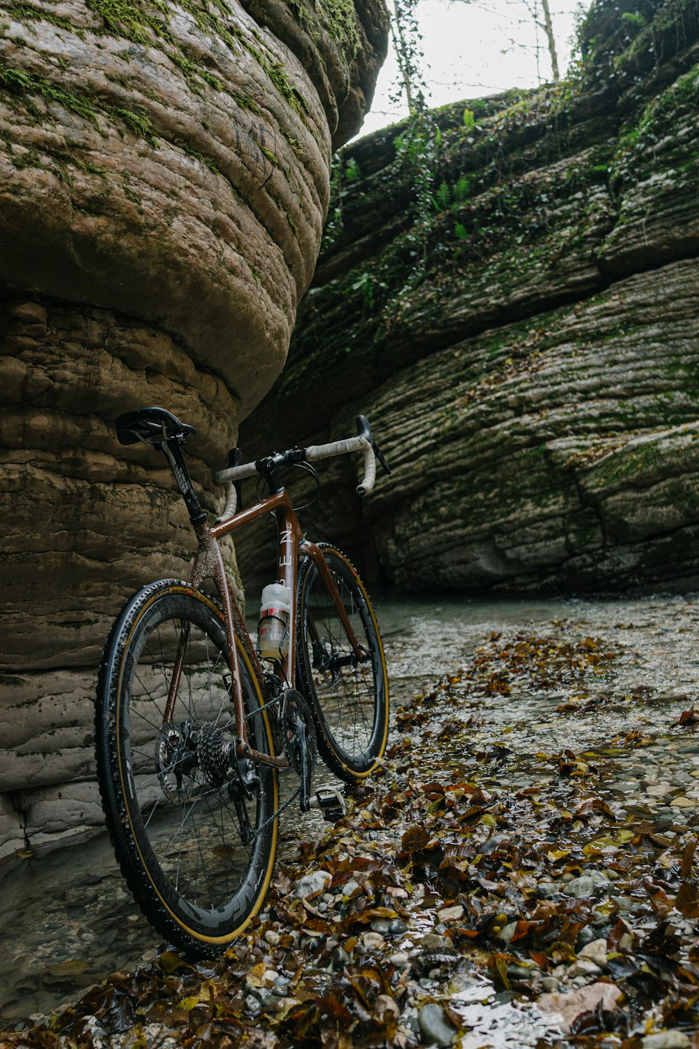 a bike parked next to a large rock formation