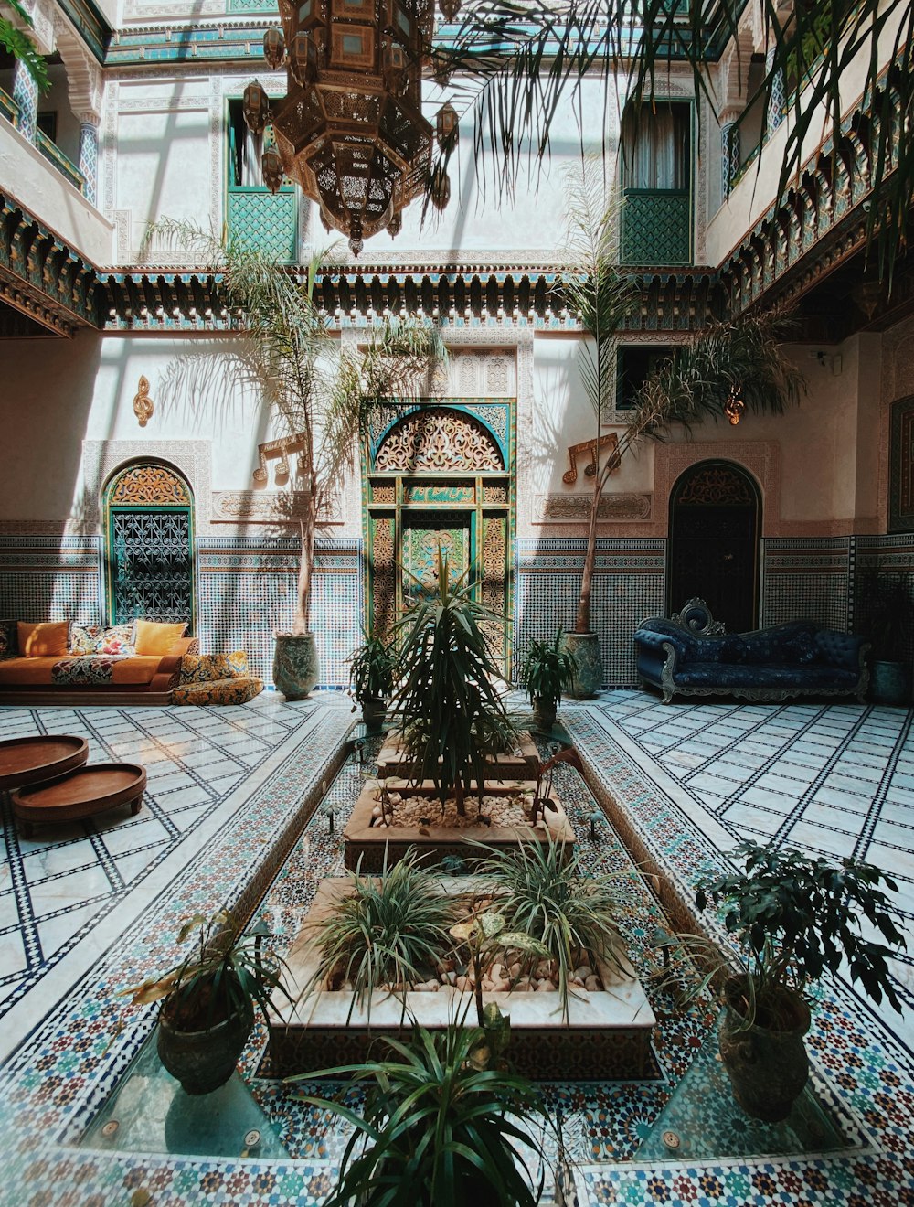 a courtyard with a fountain surrounded by potted plants