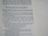 A close-up view of a page from a book, featuring a passage about the Lord Almighty. The text is focused on a specific verse, while additional text appears blurred in the foreground and background.