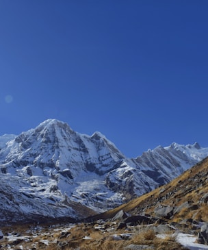 a snow covered mountain range with a clear blue sky