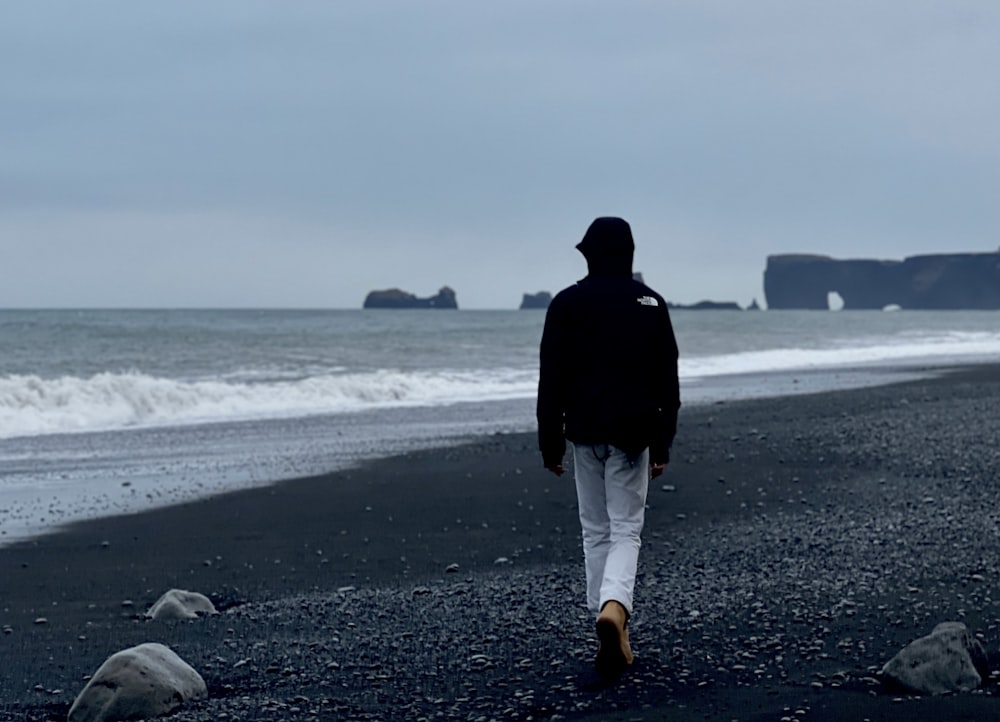 a person walking on a beach near the ocean