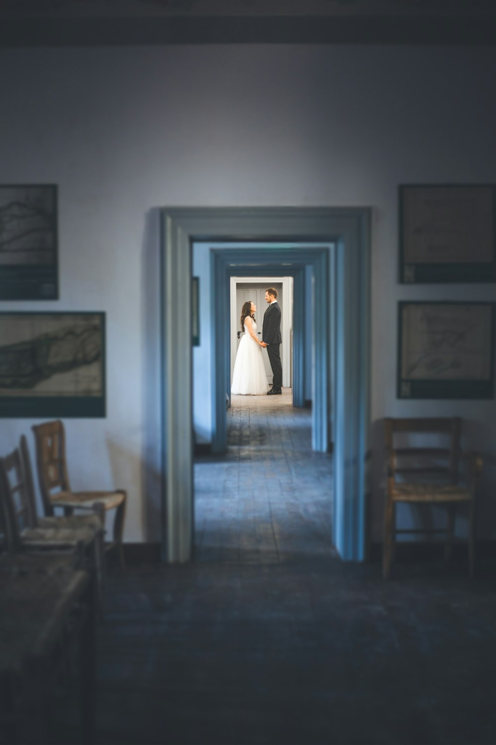 a bride and groom standing in the doorway of a building