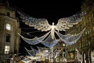 a large angel statue surrounded by lights in a city