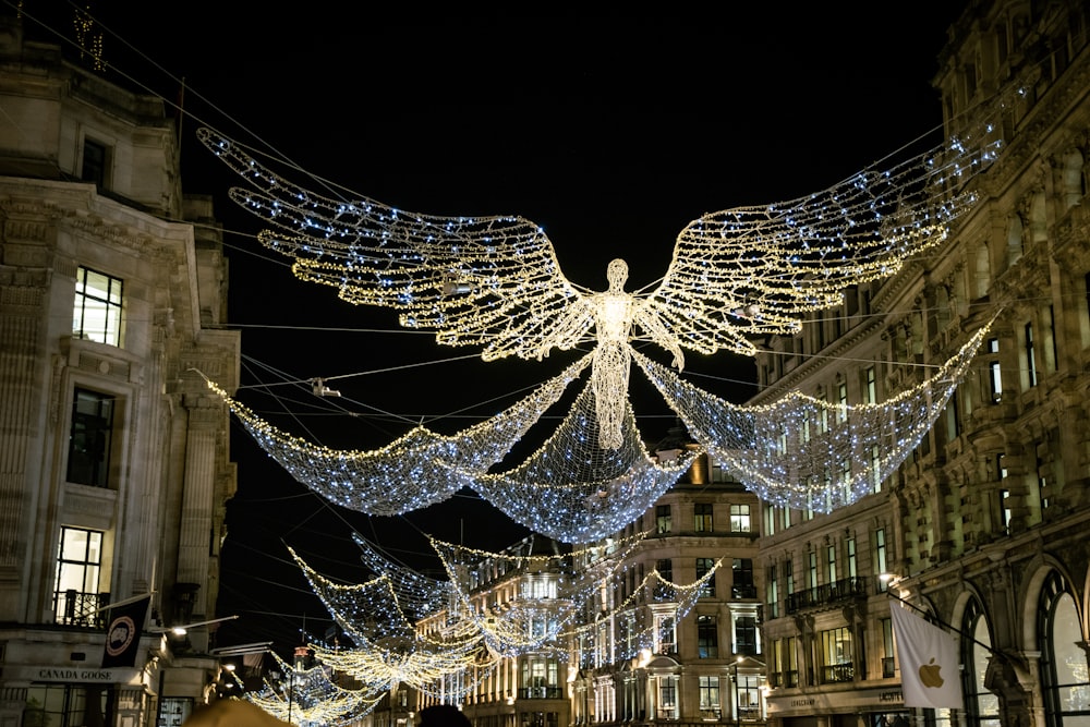 a large angel statue surrounded by lights in a city