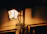 A softly lit hanging porch lantern casting warm light over a wooden porch at dusk.