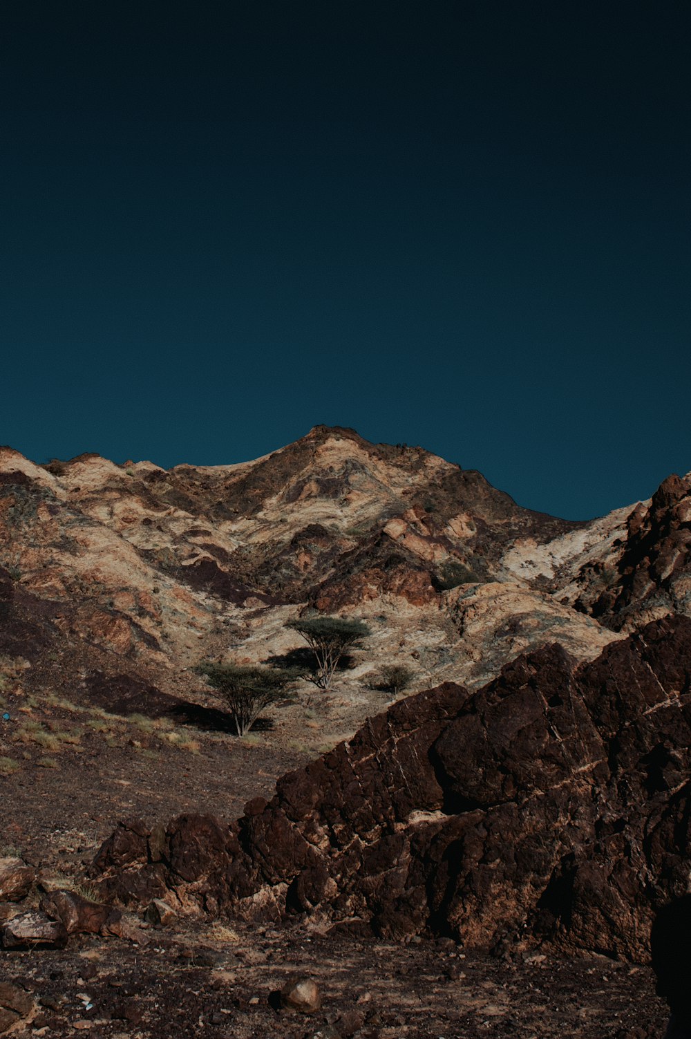 Eine Bergkette mit einem dunklen Himmel im Hintergrund