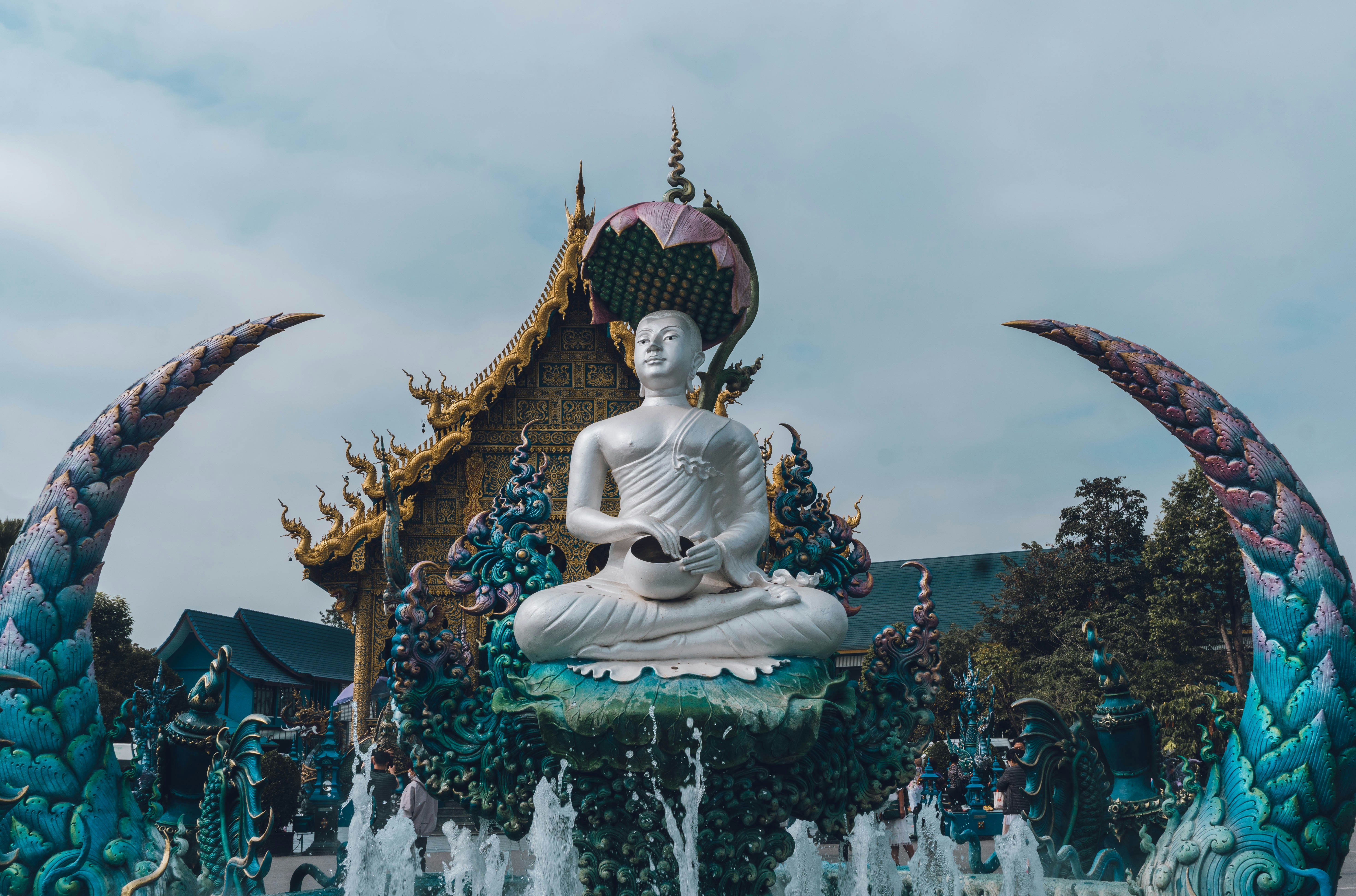 a statue of a buddha sitting in front of a fountain