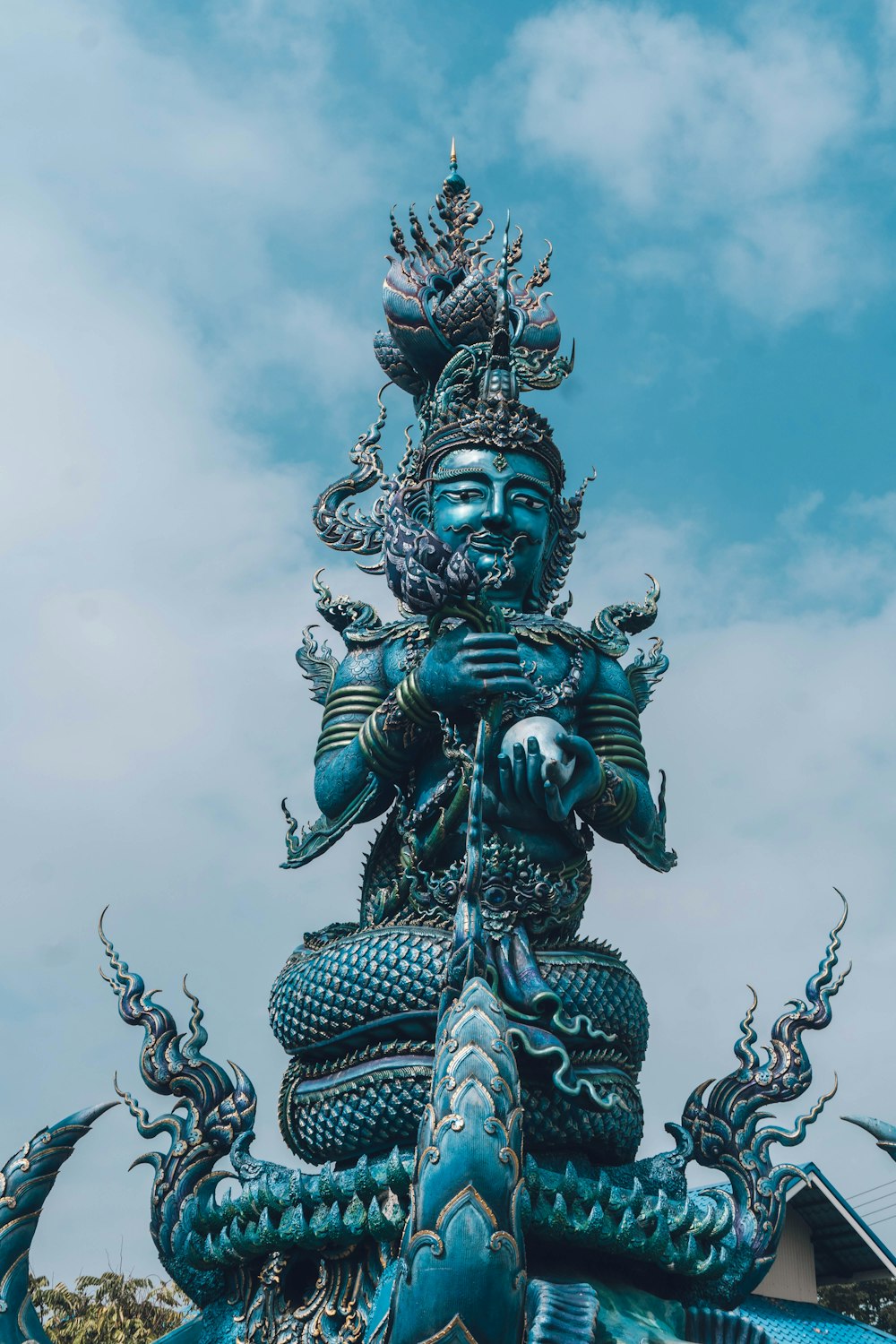 una estatua de una persona sosteniendo una serpiente en la parte superior de un edificio