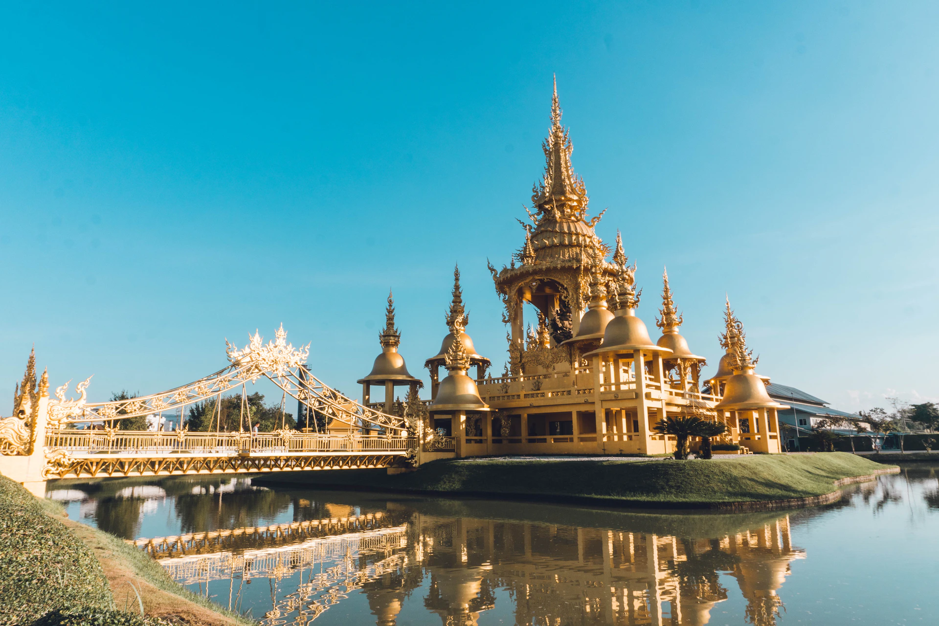 a large golden building sitting on top of a lake
