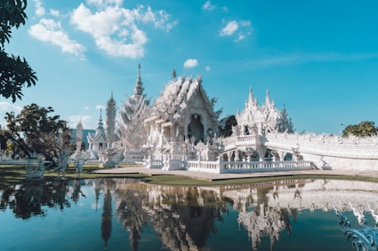 a large white building sitting next to a body of water