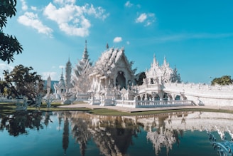 a large white building sitting next to a body of water