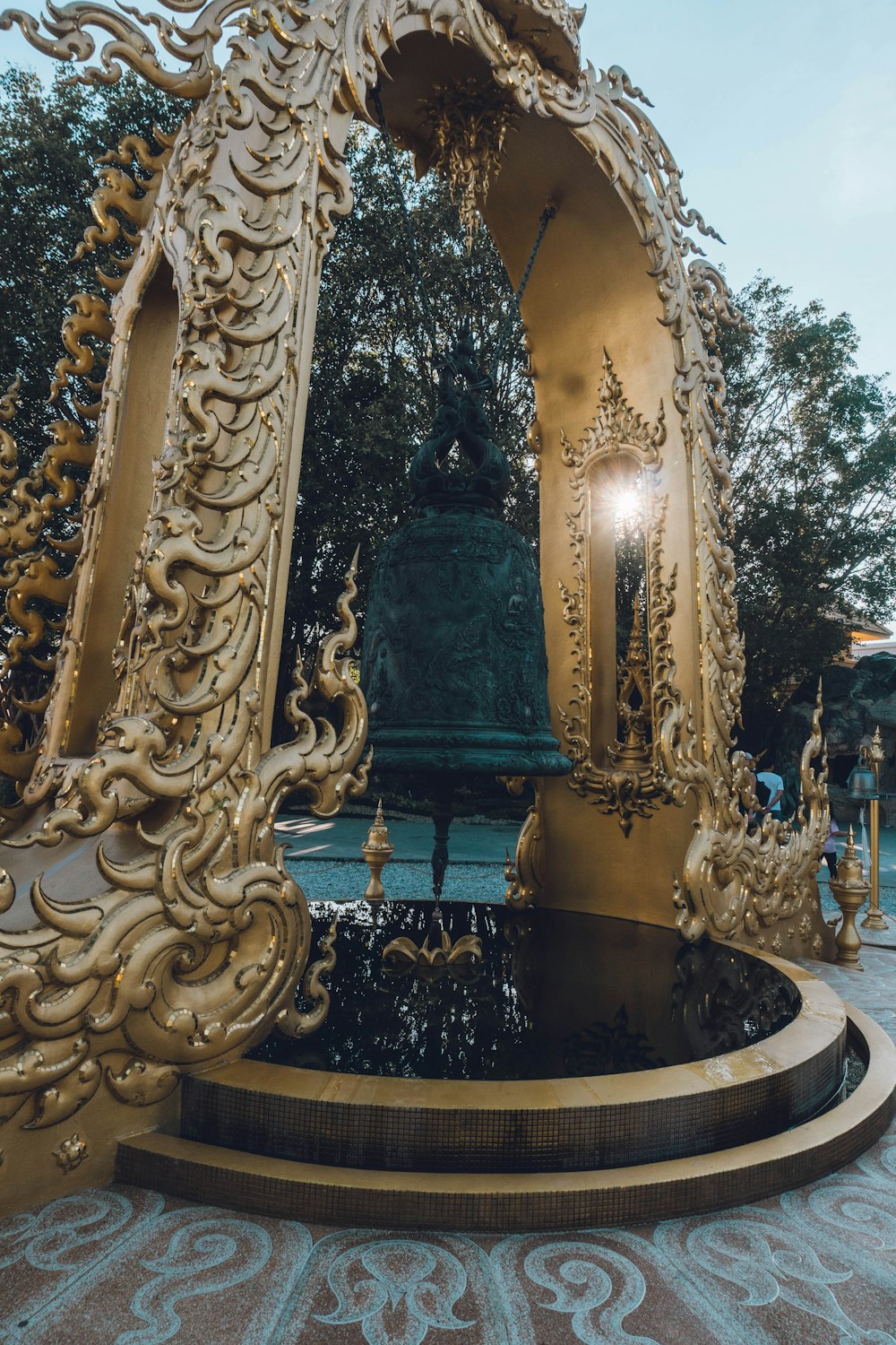 a golden statue with a fountain in the middle of it